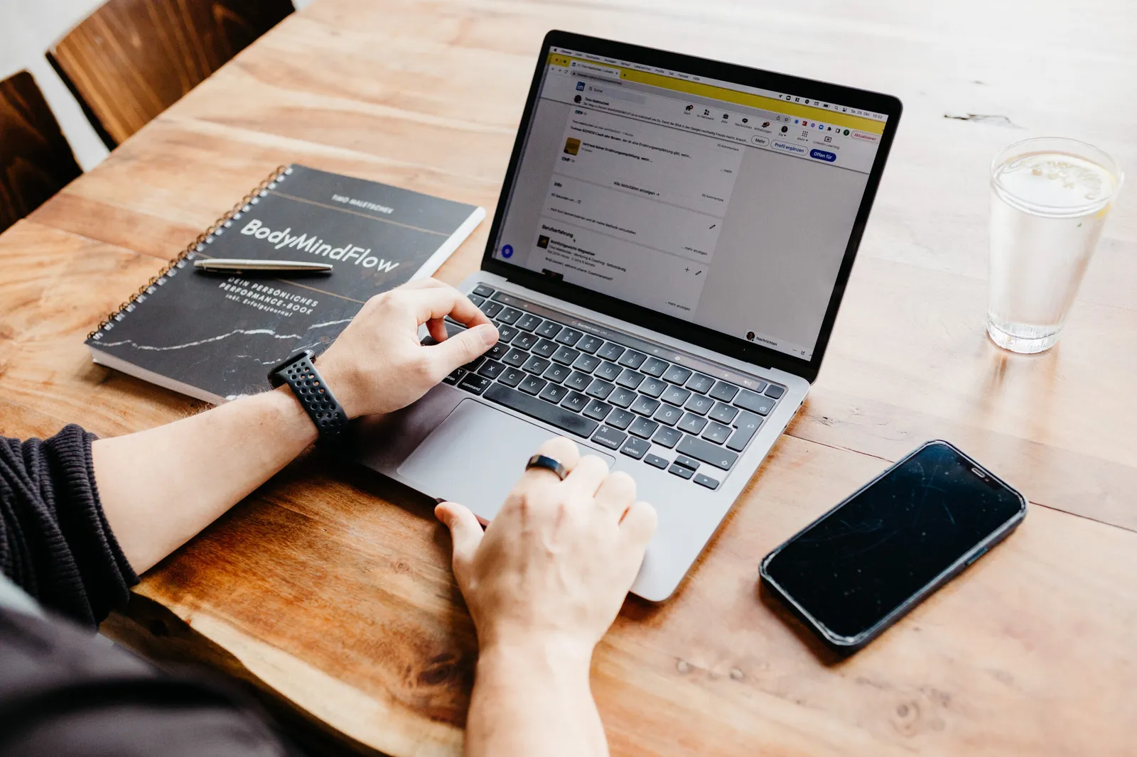 Laptop, Notizbuch und Smartphone auf dem Schreibtisch von Timo Maletschek